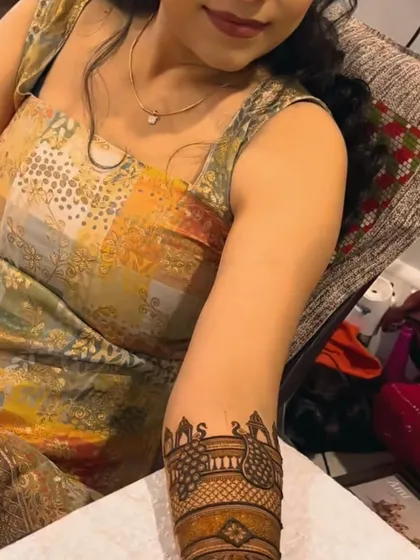 A lovely arm band design for Rakhi, featuring peacocks and the initials 'S'. It's a stylish and modern way to celebrate the festival.