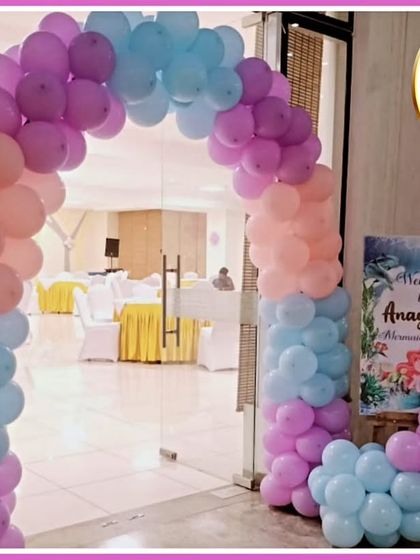 A welcoming balloon arch for a mermaid-themed party, in a lovely pastel color palette.