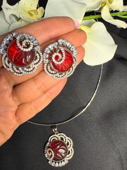 This red carved stone pendant set is a true showstopper. The intricate spiral design is surrounded by a halo of glittering American Diamonds, making it a perfect statement piece for festive occasions or a Valentine's gift.