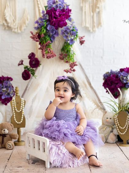 This little one looks so sweet and curious in her purple dress. Sitter sessions are all about capturing these fleeting moments of babyhood.