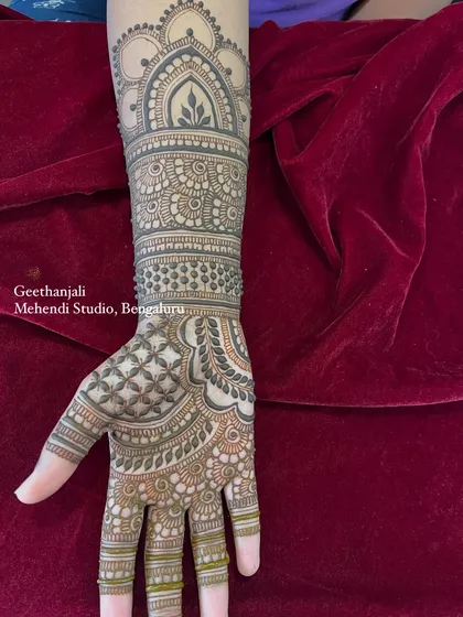 A side view of the engagement mehendi, highlighting the detailed cuff and forearm patterns.