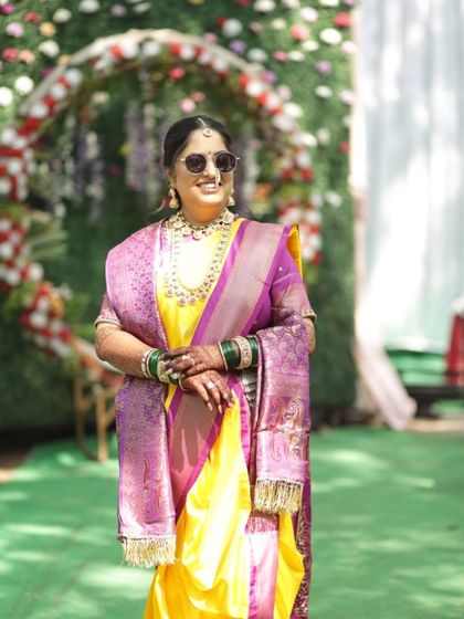 A fun shot of the bride with sunglasses, adding a modern twist to her traditional look. Her makeup remains flawless and vibrant.