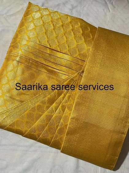 A solid gold-colored saree, folded to show its shimmer.
