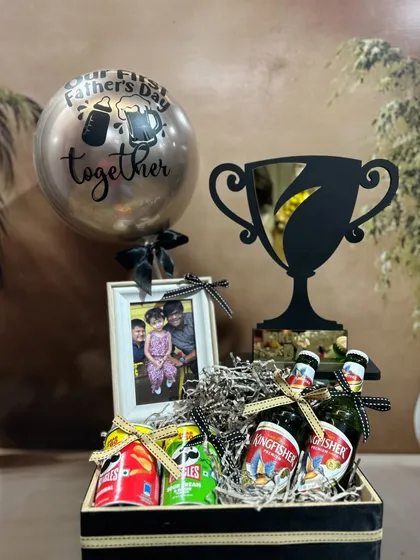 Celebrate his first Father's Day with this special hamper. It includes a "Best Dad" trophy, a personalized photo frame, a "Our First Father's Day" balloon, and his favorite snacks and drinks.