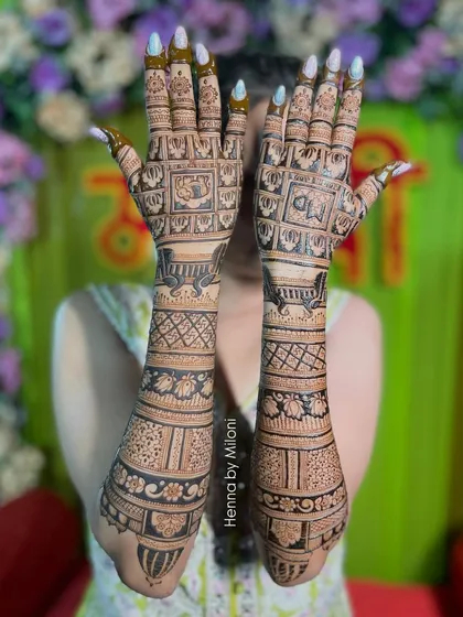 A full-coverage bridal mehendi with a variety of traditional patterns. Each band on the arm has a different design, from elephants to florals to geometric checks.
