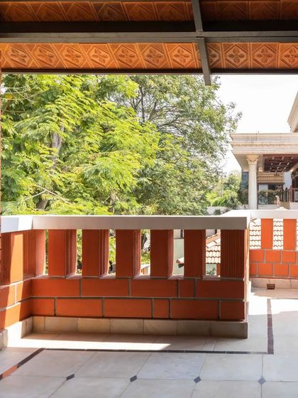 A view from the terrace, looking out over the greenery, with the brick parapet wall framing the scene.