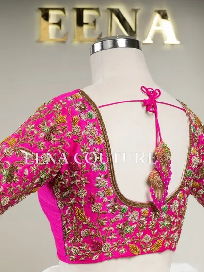 This bright pink raw silk blouse is a showcase of exquisite craftsmanship. The sleeves and back are covered in dense, multi-colored floral handwork, and I added beautiful custom tassels with bead detailing to complete the look.
