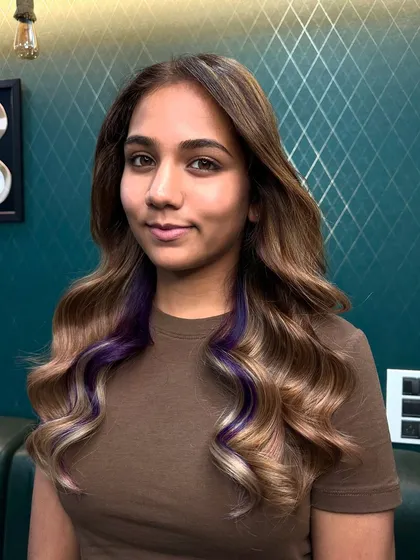A little surprise of color. These peekaboo purple highlights add a playful, trendy twist to a classic wavy hairstyle, allowing you to show off your personality when you want to. It's the perfect way to experiment with color without a full commitment.