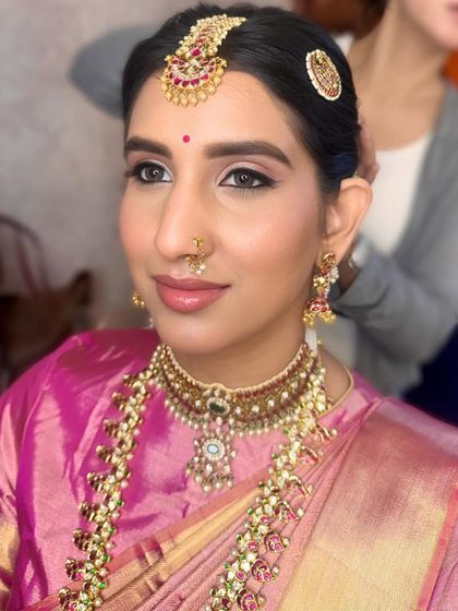 A candid shot showing the beautiful harmony between the makeup and her traditional attire. The skin remains fresh and luminous under the lights.