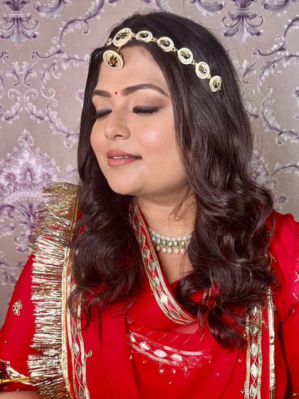 A close-up of the soft, brown-toned eye makeup, which complements the red and gold of her outfit perfectly.