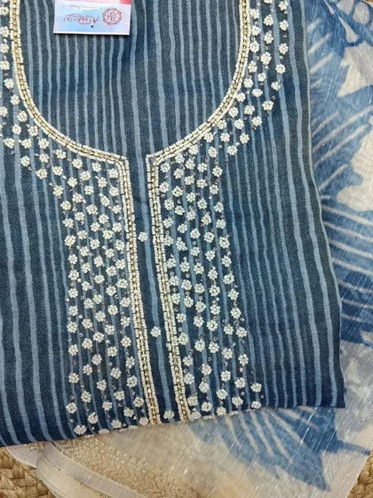 This indigo striped cotton suit piece is adorned with delicate white floral embroidery around the neckline, offering a smart and elegant look for daily wear.
