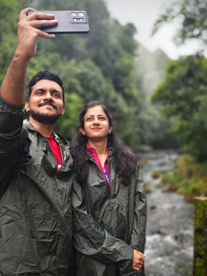 A couple takes a selfie by a river on the Kurinjal trek, capturing a happy memory.