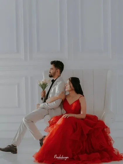Another angle of the elegant couple on the white chair, showcasing a different but equally sophisticated pose.