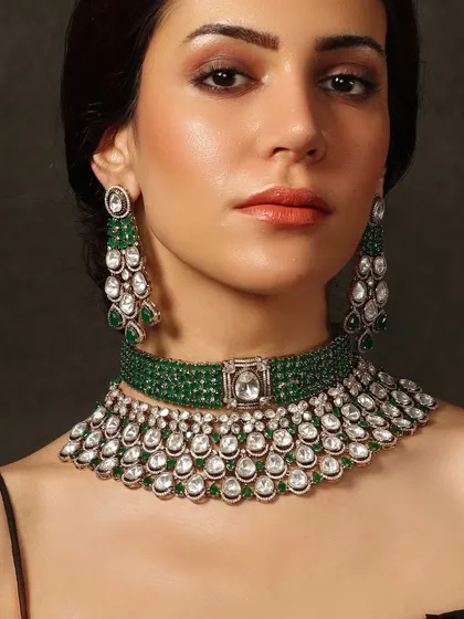 A modern bridal look featuring a layered emerald and polki choker and necklace combination, perfect for a reception or sangeet.