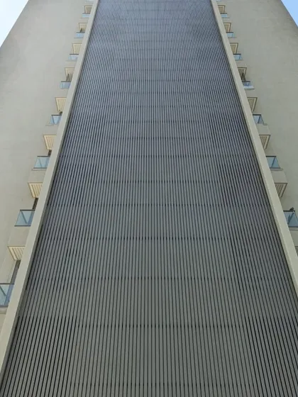 No project is too big. Here you can see a massive residential tower featuring our custom vertical metal louvers, creating a stunning visual texture and providing functional shading for the entire building facade.