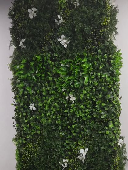 A close-up of a green wall panel with small white flowers. This shows the detail and density of the foliage I use for my installations.