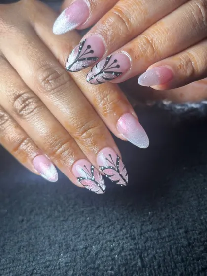 A beautiful design with a pink and white ombre base and intricate black branch-like patterns.