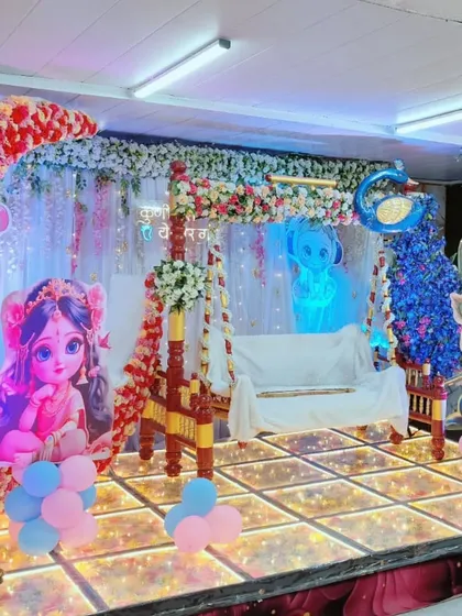 Another angle of our Krishna-themed stage for a naming ceremony. The red and white floral moon arch complements the traditional swing and backdrop, making it a picture-perfect setting.
