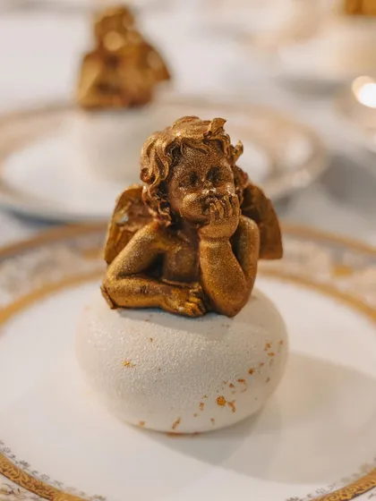An edible golden cherub dessert, meticulously crafted for a dinner inspired by the art and architecture of Versailles. This piece showcases our passion for detailed, artistic pastry work that serves as a grand finale to a thematic meal.