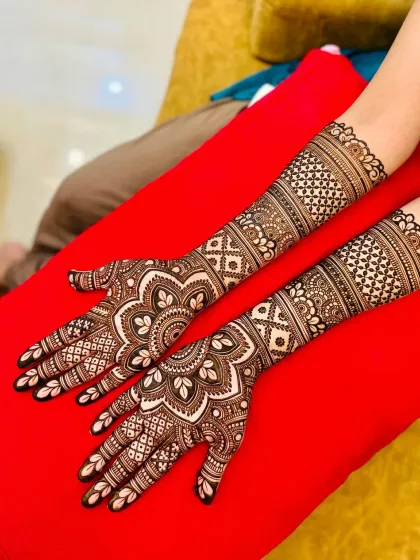 A classic full-hand bridal design featuring symmetrical mandalas on the palms and detailed jaal work covering the arms. This is a popular choice for a traditional look.