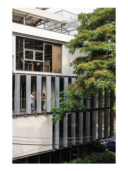The staggered balconies create opportunities for informal interaction and provide employees with a direct connection to the outdoors. The vertical concrete fins offer privacy and solar shading without obstructing the views of the surrounding trees.