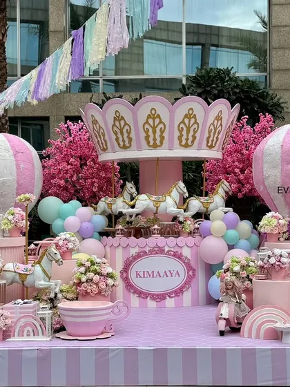 A dreamy pastel carousel theme, featuring a full-sized carousel centerpiece, hot air balloon props, and soft, whimsical colors for a truly sweet celebration.