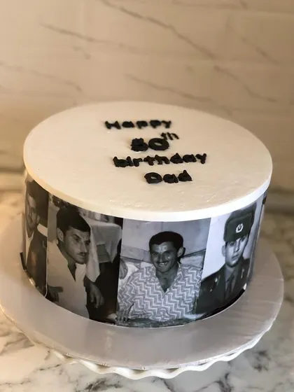 This cake was created to celebrate an 80th birthday for a beloved dad. I used a series of his life photos to create an edible memory lane wrapped around the cake. The simple message on top keeps the focus on the pictures, making it a deeply personal and heartfelt gift.