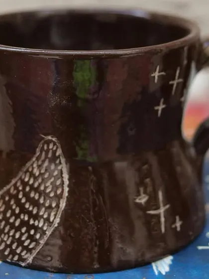 'The Lost Marines' is a set of three mugs I created using the Mishima technique on black clay. I carved the designs and inlaid them with white slip, creating a stark, beautiful contrast that I love.