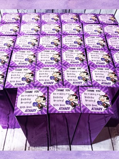 The Mr. Bean water bottles were packaged in these vibrant purple boxes with a custom thank you tag for Atharv's birthday.