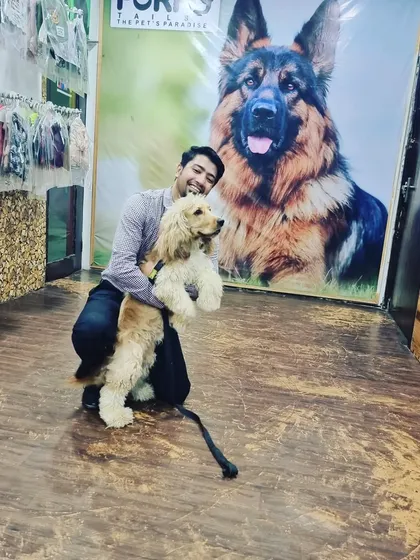 Pluto, a handsome Cocker Spaniel, poses with a team member after a two-week stay. It's always a pleasure to have long-term guests become part of the FurryTails family.