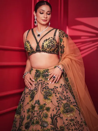 A soft and elegant pose, with Tanishaa looking down. This shot emphasizes the stunning necklace and the detailed embroidery on the blouse.