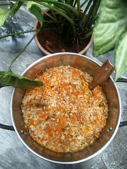 A big pot of my classic chicken and vegetable rice, ready to be portioned out for my street feeding initiative. You can see the shredded carrots and minced chicken evenly mixed throughout the rice.