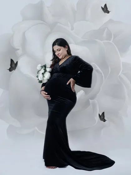 Simple, elegant, and powerful. In our studio, we create a peaceful space for you to just be. This black gown against the artistic floral backdrop is a classic look that focuses on the beautiful shape of your baby bump.