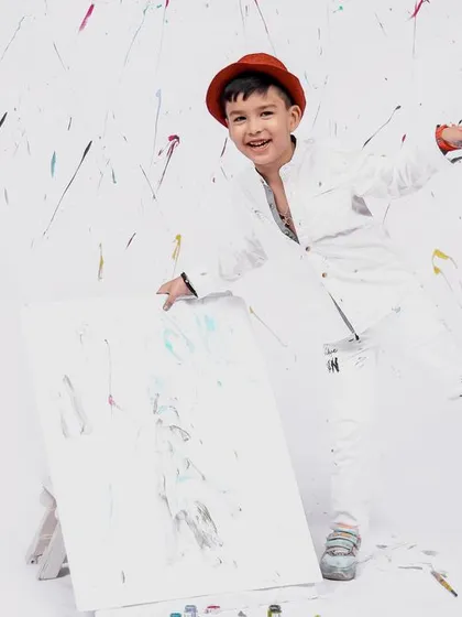 A playful shot capturing the motion and fun of our painter-themed photoshoot. This little artist is having a blast creating his masterpiece.
