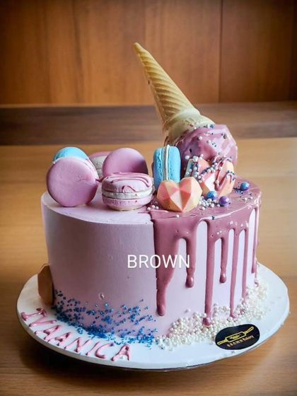 An ice cream lover's dream. This cake is designed to look like a melting ice cream cone, complete with a drip effect, sprinkles, and macarons.