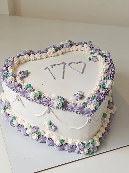 A vintage-style heart-shaped cake for a 17th birthday, decorated with intricate purple and white piping. This classic design is making a huge comeback.