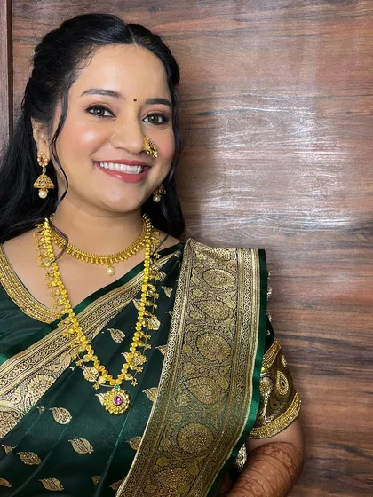 A full-length shot showing her beautiful green engagement saree and the soft, wavy hairstyle.