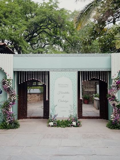 A grand entrance facade in pastel blue with peacock motifs, designed for a themed wedding, showcasing endless customization possibilities.