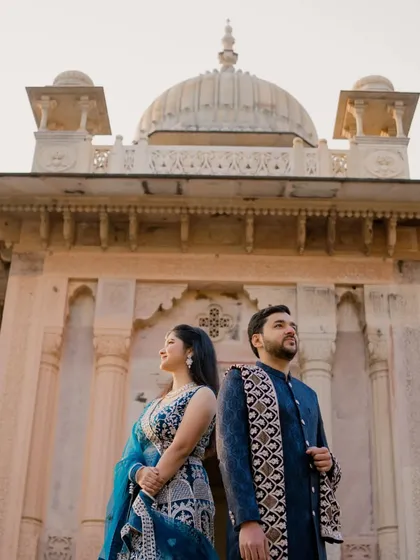 A strong, statuesque pose that highlights the couple's confidence and the grandeur of the location. This low-angle shot makes both the couple and the monument look magnificent.