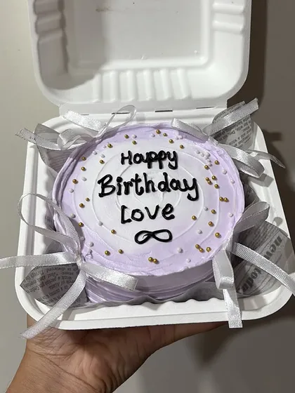 A lovely lavender-colored bento cake for a birthday. It's decorated with delicate silver ribbons and gold sprinkles for an elegant touch.
