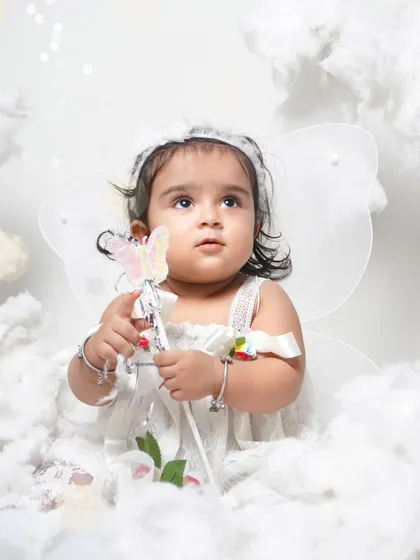 A heavenly angel theme with the baby surrounded by soft, white clouds. I use simple, elegant props like wings and a wand to create a magical atmosphere.