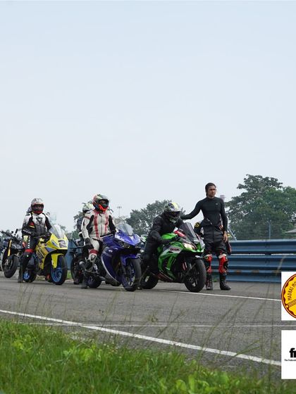 Riders lined up and ready for their next on-track session. An instructor gives some last-minute advice before they head out.