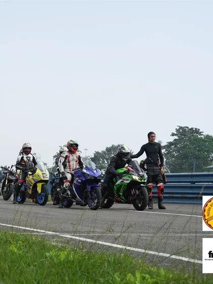Riders lined up and ready for their next on-track session. An instructor gives some last-minute advice before they head out.