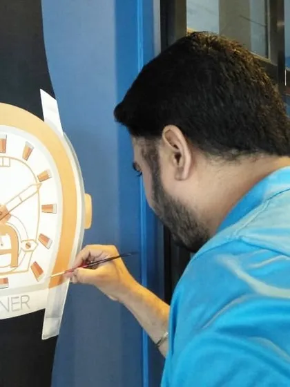 This shot shows me carefully painting the logo and details on an Aigner watch mural. Creating branded art requires precision and a steady hand, and I take great pride in delivering high-quality work that represents my client's brand perfectly.