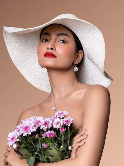 A classic, high-fashion look. The oversized white hat, bold red lip, and simple pearl jewelry create a timelessly elegant image.
