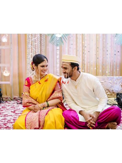 The couple seated together after the main rituals, sharing a quiet, happy moment as husband and wife.