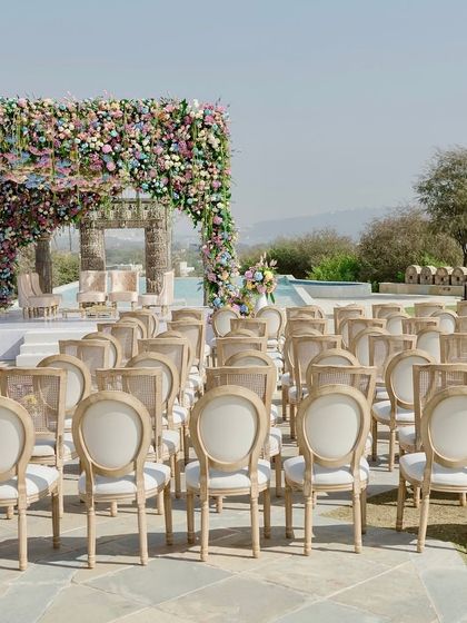 A view down the aisle, perfectly centered on the magnificent floral mandap. The symmetry and scale of the setup create a powerful visual impact.