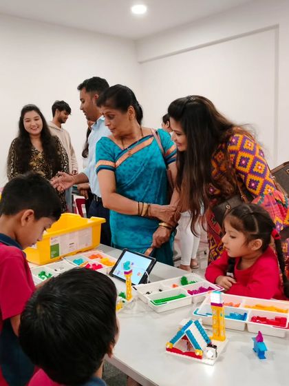 Parents and teachers mingle with students at the Vidyashilp Academy project showcase, creating a vibrant community atmosphere centered around student achievement.