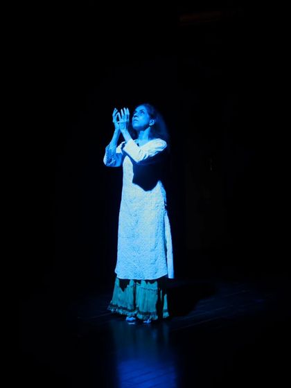 A dancer under blue light during the tech run for "Immersed."
