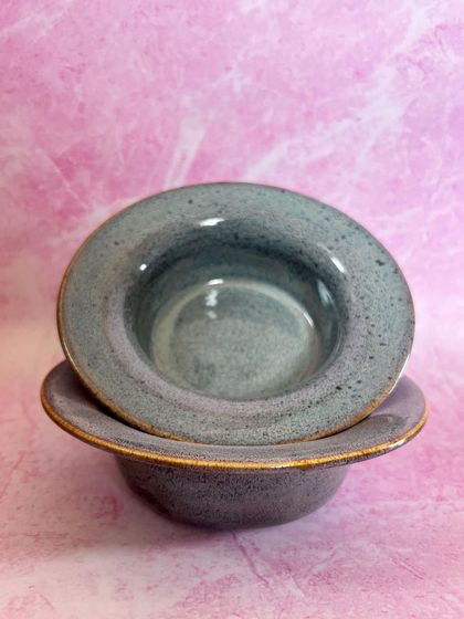 Two pasta bowls stacked, showing their uniform shape and the subtle variations in the glaze.